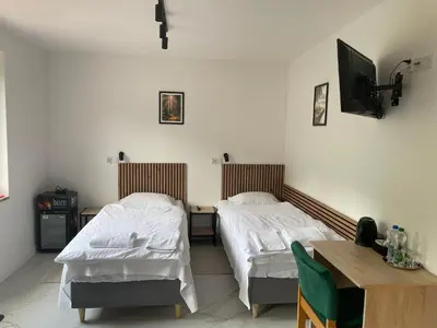 a bedroom with two beds and a table and a tv at Hotel Górsko in Wieliczka