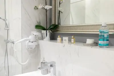 a bathroom with a sink and a mirror at Glossy Apart W21 in Kraków
