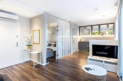 a living room with a television and a bedroom at Glossy Apart W21 in Kraków