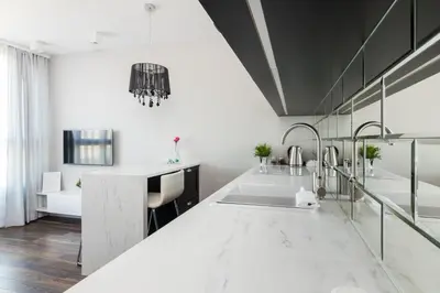 a kitchen with a white counter top and a sink at Glossy Apart W21 in Kraków
