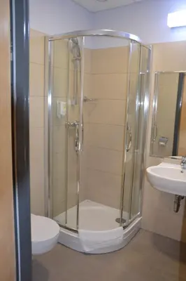 a bathroom with a shower and a toilet and a sink at Hotel Kolna - darmowy parking, basen w cenie in Kraków