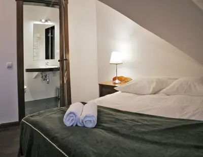 a bedroom with a bed with two towels on it at Villa Sofia in Kraków