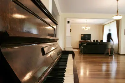 a piano in the middle of a living room at Villa Sofia in Kraków