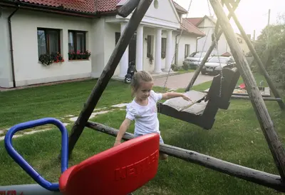 a little girl is playing on a swing at Villa Sofia in Kraków