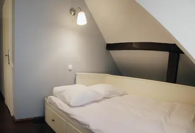 a bed with white sheets and pillows in a room at Villa Sofia in Kraków