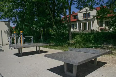 two picnic tables with a playground in a park at Villa Sofia in Kraków