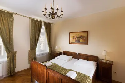 a bedroom with a bed and a chandelier at Aparthotel Camea in Kraków