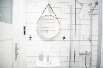 a white bathroom with a sink and a mirror at LION apartments - SILVER in Kraków