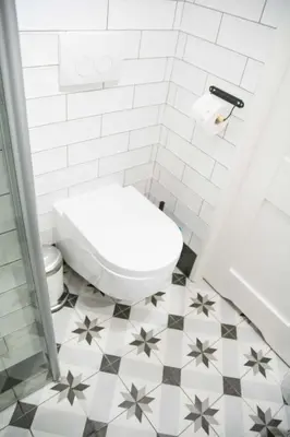 a bathroom with a toilet and a tiled floor at LION apartments - SILVER in Kraków