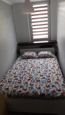 a bed with a quilt on it in a bedroom at Blue Apartment Oświęcim in Oświęcim