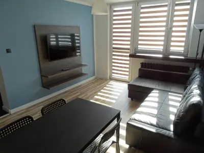 a living room with a couch and a tv at Blue Apartment Oświęcim in Oświęcim