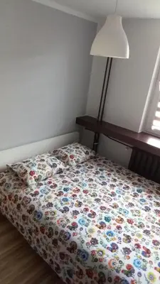 a bed with a floral comforter in a bedroom at Blue Apartment Oświęcim in Oświęcim