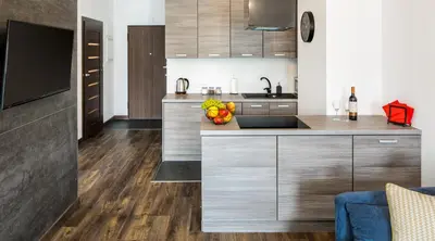 a kitchen with wooden cabinets and a counter top at Green Garden Residence in Kraków