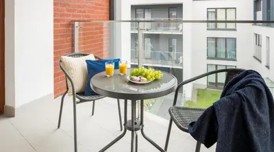 a table on a balcony with a bowl of fruit at Green Garden Residence in Kraków