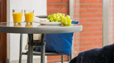 two glasses of orange juice and a plate of grapes on a table at Green Garden Residence in Kraków