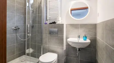 a bathroom with a shower and a toilet and a sink at Green Garden Residence in Kraków