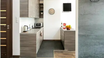 a kitchen with wooden cabinets and a counter top at Green Garden Residence in Kraków