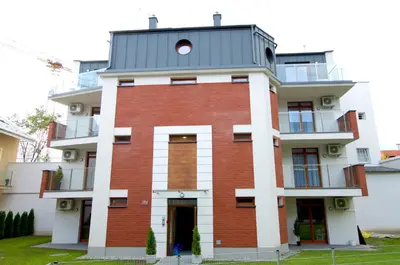 a red brick building with a grey roof at Green Garden Residence in Kraków