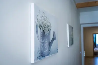 a picture of a vase of flowers on a wall at Harmony Hostel in Zator