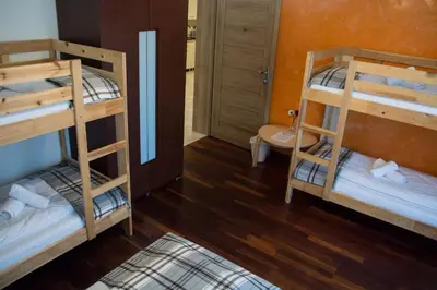a room with two bunk beds and a bathroom at Harmony Hostel in Zator