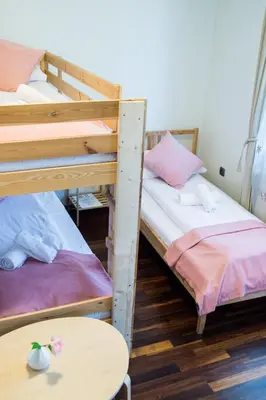 two bunk beds in a room with a table at Harmony Hostel in Zator