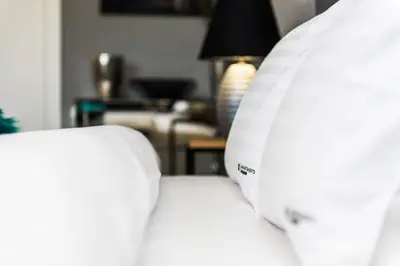 a close up of a white bed in a living room at Bed&Bath Luxury Apartments in Kraków