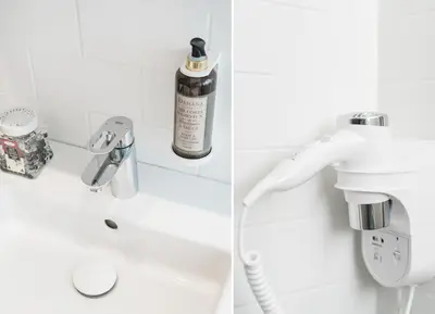 a bathroom with a sink and a bottle of alcohol at Salomea Krakow apartments in Kraków