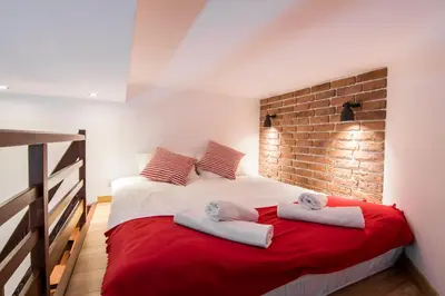 a bedroom with a bed with two towels on it at R&R Apart Cracow in Kraków