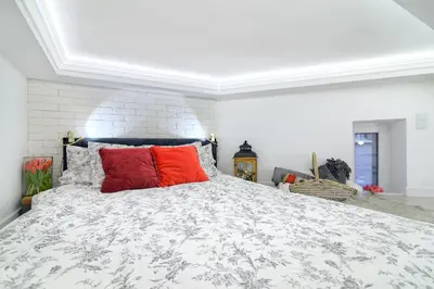 a bedroom with a large bed with red pillows at R&R Apart Cracow in Kraków