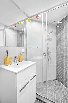 a white bathroom with a shower and a sink at R&R Apart Cracow in Kraków