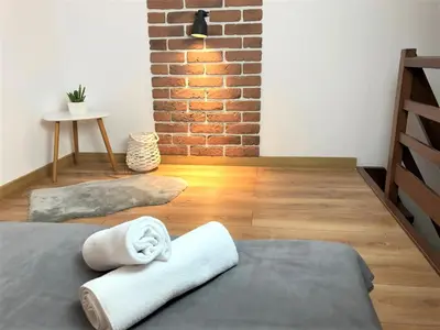 a room with a bed and a brick wall at R&R Apart Cracow in Kraków