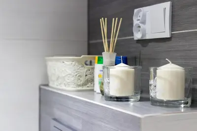 a counter with three candles on a shelf at R&R Apart Cracow in Kraków