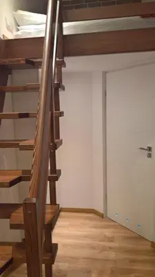 a staircase in a room with wooden floors at R&R Apart Cracow in Kraków