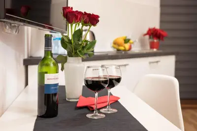 a bottle of wine and two glasses on a table at R&R Apart Cracow in Kraków