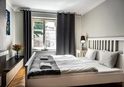 a bedroom with a large white bed with a window at Flamingo Premium Hostel in Kraków