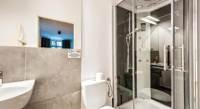 a bathroom with a shower and a toilet and a sink at Flamingo Premium Hostel in Kraków