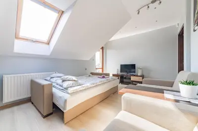 a bedroom with a bed and a living room at Pokoje Goscinne u Florka in Słopnice