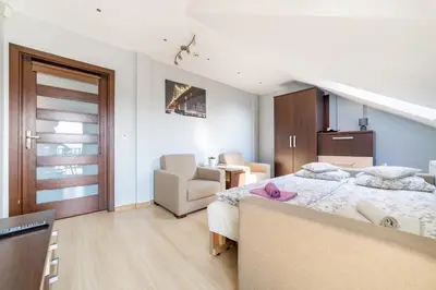 a bedroom with a bed and a couch and a chair at Pokoje Goscinne u Florka in Słopnice