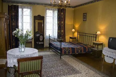 a bedroom with a bed and a table and a tv at Austeria Klezmer Hois in Kraków