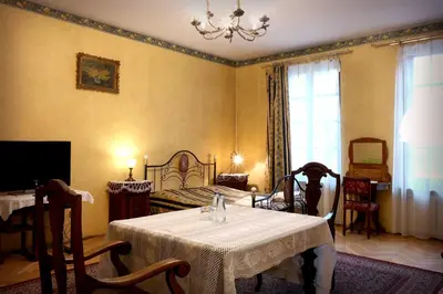 a bedroom with a table and a bed and a chandelier at Austeria Klezmer Hois in Kraków