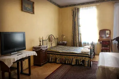 a bedroom with a bed and a tv and a window at Austeria Klezmer Hois in Kraków