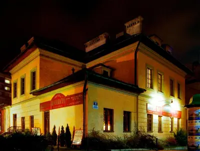 a large building with lights in front of it at night at Austeria Klezmer Hois in Kraków