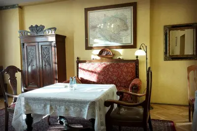 a room with a table and a chair and a mirror at Austeria Klezmer Hois in Kraków