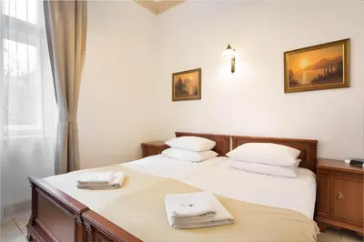 a hotel room with two beds and a television at Ventus Rosa Self Service Apartments in Kraków