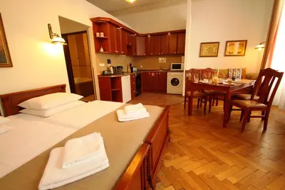 a kitchen and living room with a table and chairs at Ventus Rosa Self Service Apartments in Kraków