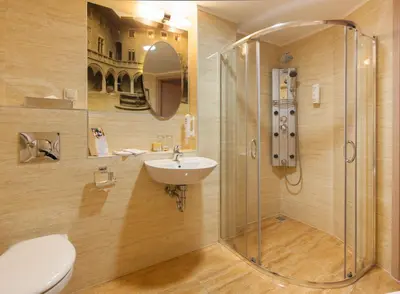a bathroom with a shower and a sink and a toilet at Galaxy Hotel in Kraków