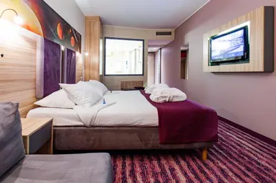 a hotel room with a bed and a tv at Galaxy Hotel in Kraków