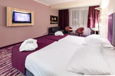 a hotel room with two beds and a tv at Galaxy Hotel in Kraków