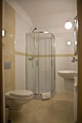 a bathroom with a shower and a toilet and a sink at Hotel Vinnica in Wieliczka