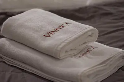 two white towels sitting on top of a bed at Hotel Vinnica in Wieliczka